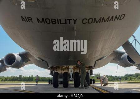 U.S. Air Force Tech. Sgt. Jake Schlemmer, a flight engineer assigned to the 709th Airlift Squadron, poses under a U.S. Air Force Lockheed C-5 Galaxy transport aircraft at McEntire Joint National Guard Base, S.C., July 8, 2016. Approximately 300 U.S. Airmen and 12 F-16 Fighting Falcon jets from the 169th Fighter Wing at McEntire JNGB, S.C., are deploying to Osan Air Base, Republic of Korea, as the 157th Expeditionary Fighter Squadron in support of the U.S. Pacific Command Theater Security Package. (U.S. Air National Guard photo by Airman 1st Class Megan Floyd) SCANG TSP 747 Cargo Load 160708-Z- Stock Photo