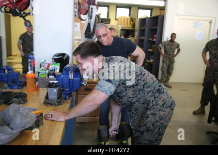 Lance Cpl. Kyle Lukoskie, a mechanic with Special Purpose Marine Air-Ground Task Force Crisis Response-Africa does some bent over curls with Celebrity Chef Robert Irvine at Naval Air Station Sigonella, Italy, July 28, 2016.  Marines displayed some of their capabilities and vehicles for Irvine and had a chance to have conversations with him. (U.S. Marine Corps photo by Cpl. Alexander Mitchell/released) Chef Robert Irvine spends time with Marines in Italy 160728-M-KS936-099 Stock Photo