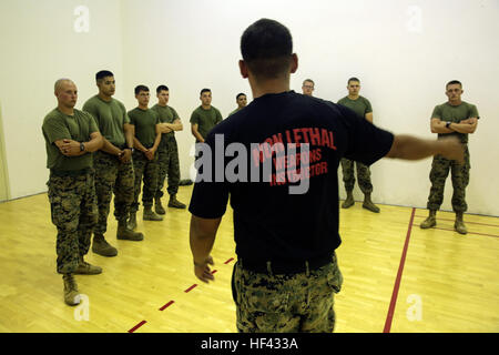 U.S. Marine Corps Staff Sgt. Joseph Mendoza a non-lethal weapons instructor with Special Purpose Marine Air-Ground Task Force Crisis Response-Africa, instructs Marines on Mechanical Arm-Control Hold techniques during a non-lethal course at Naval Air Station Sigonella, Italy, Aug. 3, 2016. Marines were taught show-of-force tactics, how to restrain a non-combative individual and experienced OC spray and the X-26E TASER during the course. U.S. Marines and Sailors assigned to Special Purpose Marine Air-Ground Task Force-Crisis Response-Africa Command support operations, contingencies and security  Stock Photo