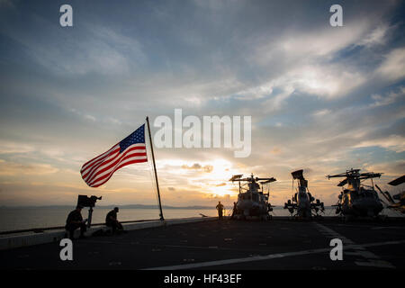 ABOARD USS GREEN BAY (LPD-20), (Aug. 21, 2016) - The sun sets over the USS Green Bay (LPD-20) at White Beach Naval Base, Okinawa, Japan, Aug. 21, 2016.   Marines of the 31st MEU are currently embarked on ships of the USS Bonhomme Richard Expeditionary Strike Group for a scheduled fall patrol of the Asia-Pacific Region.   The 31st MEU is the Marine Corps’ only continuously forward-deployed Marine Air-Ground Task Force, and is task-organized to address a range of military operations in the Asia-Pacific region, from force projection and maritime security to humanitarian assistance and disaster re Stock Photo