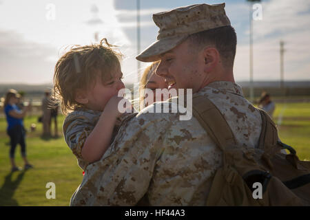 Lance Cpl. McCoy Sloan, assaultman, 2nd Battalion, 7th Marine Regiment, greets his son, Landon, 2, and wife, Lindsey Sloan, during a homecoming at Del Valle Field aboard the Marine Corps Air Ground Combat Center, Twentynine Palms, Calif., Oct. 5, 2016. The unit is returning from deployment with Special Purpose Marine Air Ground Task Force-Crisis Response-Central Command 16.2. (Official Marine Corps photo by Cpl. Levi Schultz/Released) Yielding to none, 'War Dogs' come home 161005-M-PS017-040 Stock Photo