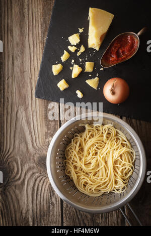 Cooking spaghetti with cheese on the old table vertical Stock Photo