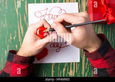 Male hands writing a calligraphy Valentines day card Stock Photo