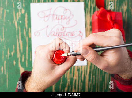 Male hands writing a calligraphy Valentines day card Stock Photo