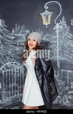 young beautiful caucasian woman on background of drawing winter street Stock Photo
