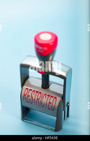 Hand stamp with the word RESTRICTED in uppercase on the label in red lettering Stock Photo