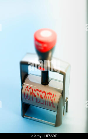 Hand stamp with the words CONFIDENTIAL in upper case on the label in red lettering Stock Photo