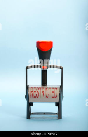 Hand stamp with the words RESTRICTED in upper case on the label in red lettering Stock Photo