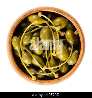 Pickled caper berries in wooden bowl. Edible fruits of Capparis spinosa, caper bush or Flinders rose. Stock Photo