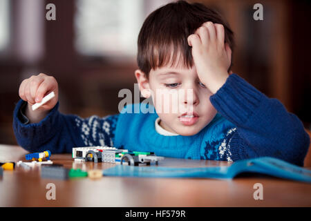 Concentrated child reading a manual Stock Photo