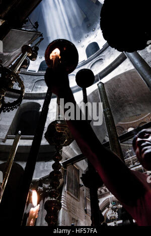 Jerusalem, Israel - May 30, 2014: Pilgrim in front of the entrance to Aedicula, place believed to be Christ’s tomb. Aedicula is encircled by a Rotunda Stock Photo