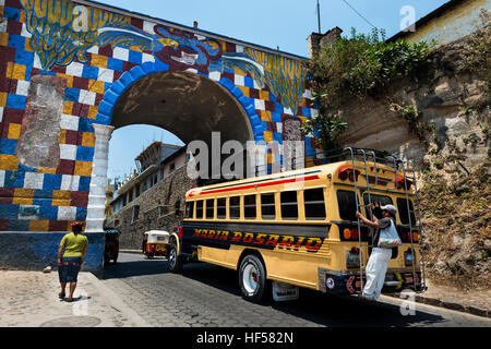 Chichicastenango, Guatemala - April 26, 2014: Bus with one man holding to a bar in the back entering the town of Chichicastenango, in Guatemala Stock Photo