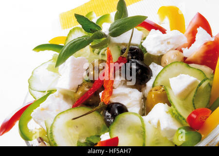 Greek specialty: feta, cucumbers, peppers, olives, dried chili peppers, sage leaves and garlic cloves Stock Photo
