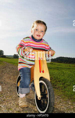 Three-year-old girl riding a bicycle Stock Photo