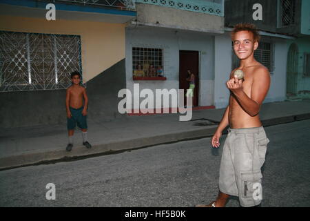 Teens playing a local version of baseball on the street in Cienfuegos, Cuba, Caribbean, Americas Stock Photo