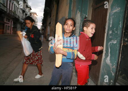 Two girls leaving a bakery with a loaf of bread, Havana, Cuba, Caribbean, Americas Stock Photo