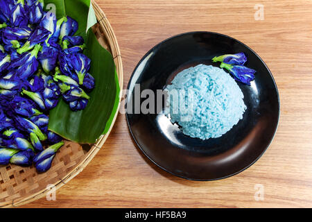 Blue Rice made cooking from Butterfly Pea flower (Clitoria ternatea L) in the black dish. Rice has a colorful and fragrant flower and good for health. Stock Photo