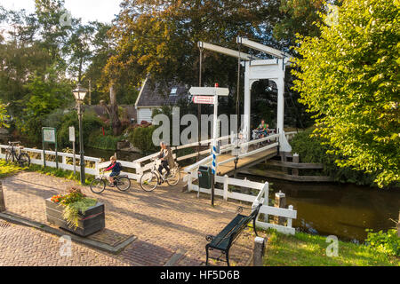 Mothers and children on bicycles cycling home from school in Broek in Waterland 6 km 4 mile North of Amsterdam Stock Photo