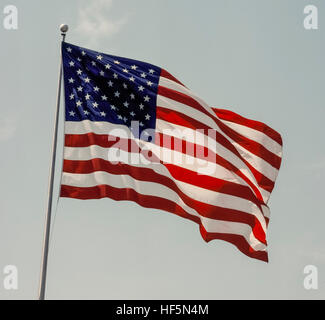 The national flag of the United States of America is known variously as the American flag, The Stars and Stripes, Old Glory, and The Star-Spangled Banner. The 50 five-pointed small white stars on a blue rectangular field represent the the 50 states of the U.S.A., while the 13 alternating red and white horizontal stripes represent the 13 British colonies in America that declared independence from Great Britain. Adopted in 1960, this is the 27th version of the U.S. flag that was first designed in 1777. Stock Photo