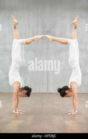 Beautiful Yoga: woman doing handstand posture Stock Photo