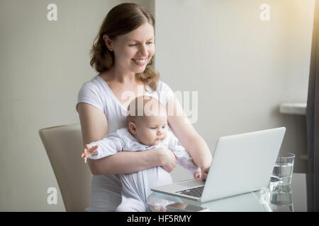 Woman and a baby near the laptop Stock Photo