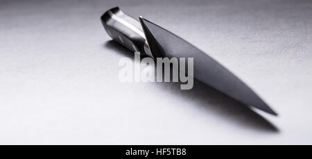 Knife. Kitchen knife lying on an modern concrete cutting board. Stock Photo