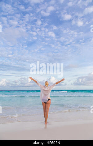 Woman enjoying Anse Lazio picture perfect beach on Mahe Island, Seychelles. Stock Photo