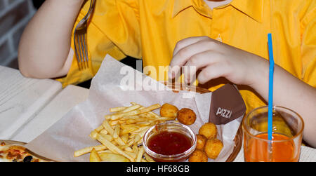 fragment of the child eating French fries in cafe Stock Photo