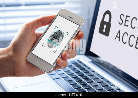 Person using fingerprint scanning on mobile phone for biometrics security, computer in background Stock Photo