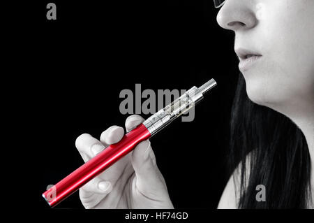 Young woman smokes an electronic cigarette. Abstract wallpaper with isolated color Stock Photo