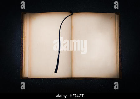 Old book on black stone with empty page for your text Stock Photo