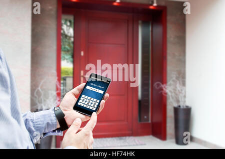 Man uses smartphone to open the door of his house Stock Photo