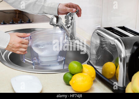Man fills filter jug with tap water Stock Photo