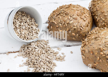 Bread with sunflower seeds. Composition on a white wooden board. Stock Photo