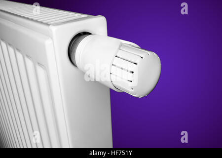 Radiator with thermostat valve isolated on violet gradient Stock Photo