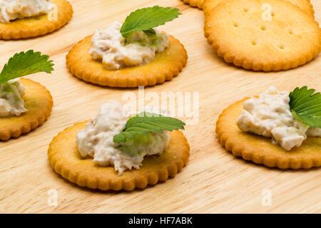 Biscuit crackers with tuna salad on wooden board Stock Photo