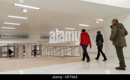 Commuters and other travelers pass through the newly opened World Trade Center connecting passageway in New York on Monday, December 19, 2016. The passage, which connects the Chambers Street subway station with the WTC Oculus and further on the PATH station, is a vestige from the original World Trade Center, destroyed in the terrorist attack on Sept. 11, 2001. The ramp and the travertine flooring are original as well as a commemorative door, labeled 'MATF1 9-13' indicating the area was searched by the Massachusetts Task Force 1 Urban Search and Rescue Team on September 13. (© Richard B. Levine Stock Photo