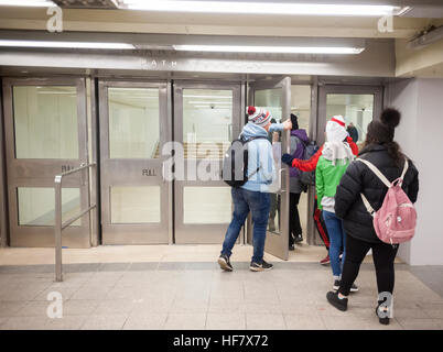 Commuters and other travelers pass through the newly opened World Trade Center connecting passageway in New York on Monday, December 19, 2016. The passage, which connects the Chambers Street subway station with the WTC Oculus and further on the PATH station, is a vestige from the original World Trade Center, destroyed in the terrorist attack on Sept. 11, 2001. The ramp and the travertine flooring are original as well as a commemorative door, labeled 'MATF1 9-13' indicating the area was searched by the Massachusetts Task Force 1 Urban Search and Rescue Team on September 13. (© Richard B. Levine Stock Photo