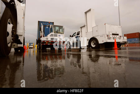A shipping container pulled by a port vehicle is scanned by truck-mounted radiation detection systems operated by U.S. Customs and Border Protection officers at the Port of Miami in Miami Fla., Dec. 07, 2015. U.S.  by Glenn Fawcett Stock Photo