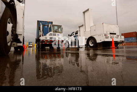 A shipping container pulled by a port vehicle is scanned by truck-mounted radiation detection systems operated by U.S. Customs and Border Protection officers at the Port of Miami in Miami Fla., Dec. 07, 2015. U.S.  by Glenn Fawcett Stock Photo
