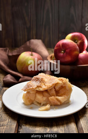 Piece of apple pie ad fresh fruits on wooden table Stock Photo