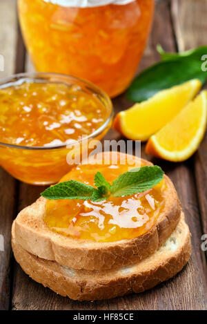Orange jam on toast bread over wooden table Stock Photo