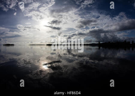 Early morning light falls on the calm water surrounding remote islands in the Solomon Islands. Stock Photo