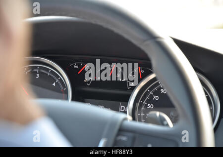 Closeup image of car dashboard through steering wheel during the day Stock Photo