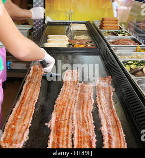 meat cooked on the hot plate in the stand of street foods Stock Photo