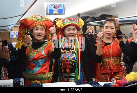 Kunming. 28th Dec, 2016. People celebrate on a train on the Shanghai-Kunming line, Dec. 28, 2016. China on Wednesday put into operation one of the world's longest high-speed railways, linking the country's prosperous eastern coast to the less-developed southwest. The Shanghai-Kunming line -- 2,252 km in length -- traverses the five provinces of Zhejiang, Jiangxi, Hunan, Guizhou and Yunnan and cuts travel time from Shanghai to Kunming from 34 to 11 hours, according to China Railway Corporation. © Lin Yiguang/Xinhua/Alamy Live News Stock Photo