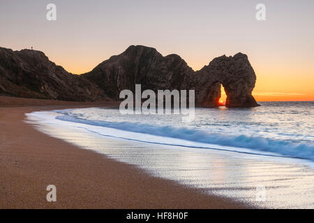 Durdle Door, Lulworth, Dorset, UK.  29th December 2016.  UK Weather.  A sparkling sunrise shines through the limestone arch of Durdle Door on the Dorset Jurassic Coast on a clear December winters morning.  Photo by Graham Hunt/Alamy Live News Stock Photo