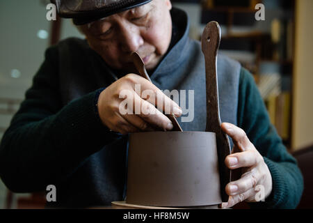 Yixing, China's Jiangsu Province. 29th Dec, 2016. Gu Shaopei makes a Yixing clay teapot at a studio in Yixing, east China's Jiangsu Province, Dec. 29, 2016. Gu, an inheritor of the technique of Yixing pottery making, has been making teapots for over 50 years. There are 6,587 specialists engaged in pottery making in Yixing, a major ceramic production center in China. © Ji Chunpeng/Xinhua/Alamy Live News Stock Photo