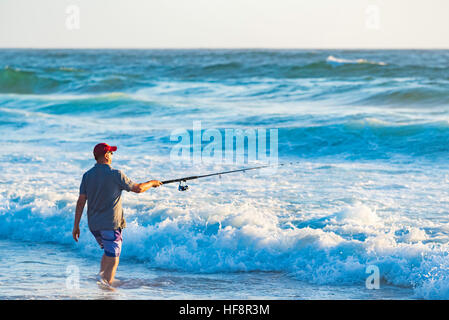 Man beach fishing with fishing rod standing on reef at Guilderton