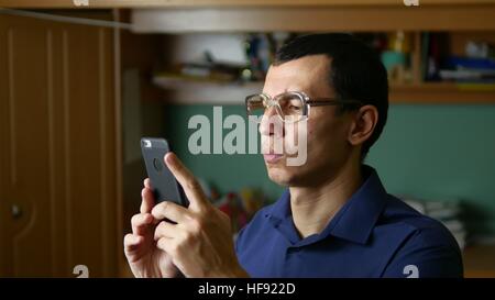 middle-aged man doing selfie photo with glasses and shirt indoor Stock Photo